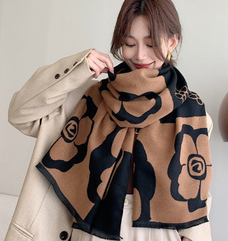 Woman wearing a beige coat with a black and brown patterned scarf